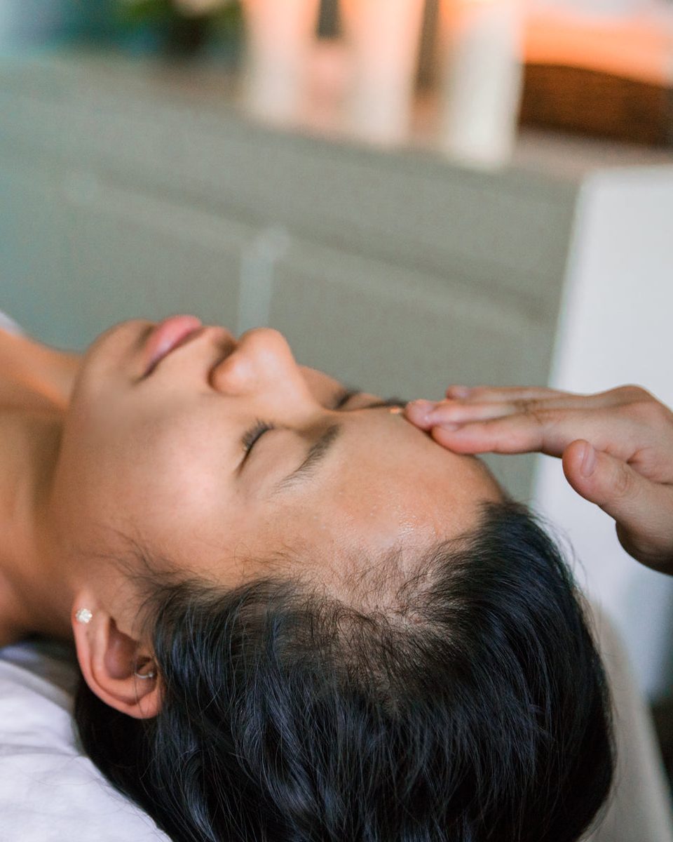 The Magma Spa Esenyurt'ta mum ışığında alnına nazik baş masajı uygulanan, gözleri kapalı rahatlayan misafir