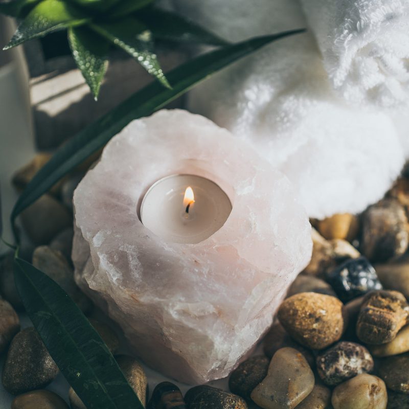 Doğal taşlar arasında kaya tuzu mumluk ve yanan mumlarla hazırlanmış spa ritüeli